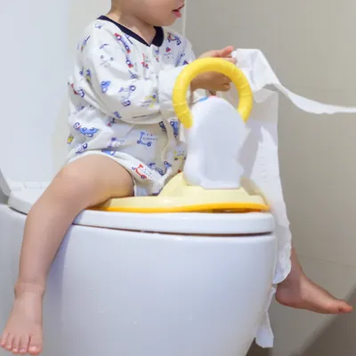 トイレで補助便座に座る子ども